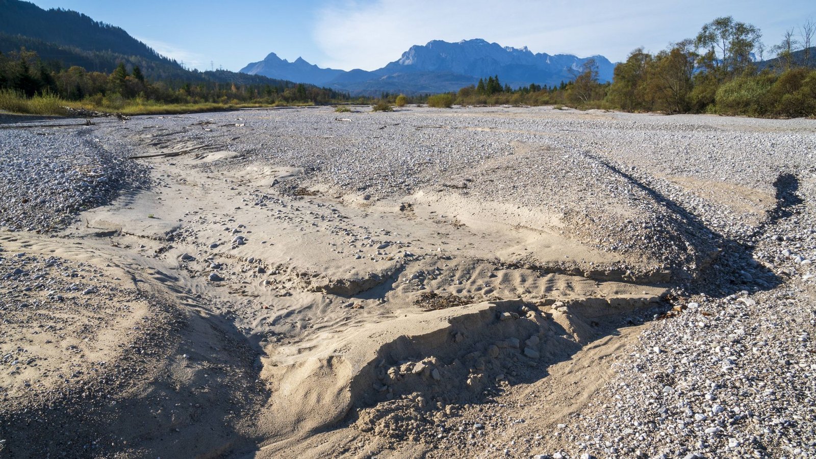 Klimakrisen, wie sie der Roman „Tomorrow Land“ in der Zukunft inszeniert, sind schon jetzt zu erleben: wasserlose Isar im Sommer 2024.Foto: IMAGO/Wolfilser