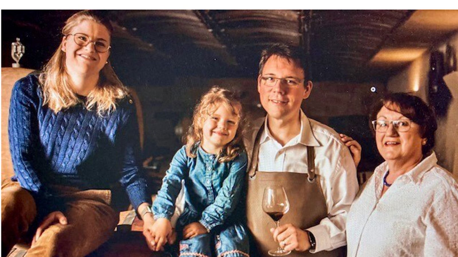 Ein Familienporträt: Stéphanie de Longueville und Markus Drautz mit ihrer Tochter und der Oma im Barriquekeller des Weinguts.Foto: Weingut Drautz-Able