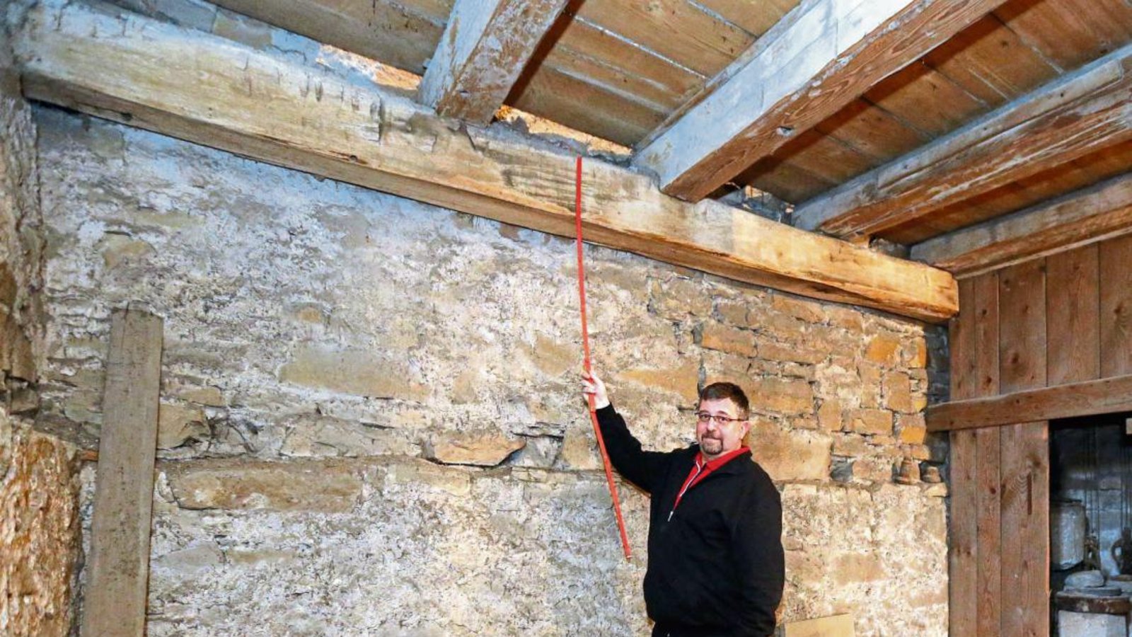 Pfarrer Johannes Rau misst nach: Der Balken aus dem Jahr 1409 ist 27 Zentimeter dick und etwas mehr als fünf Meter lang. Fotos: Küppers