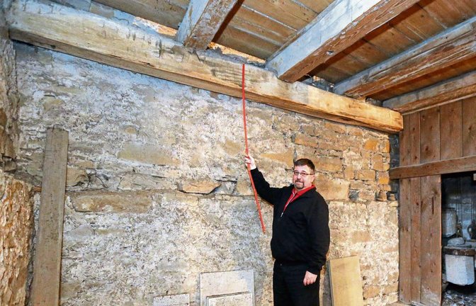 Pfarrer Johannes Rau misst nach: Der Balken aus dem Jahr 1409 ist 27 Zentimeter dick und etwas mehr als fünf Meter lang. Fotos: Küppers