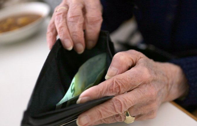 Eine ältere Frau öffnet ihr Portemonnaie. Frauen kommen nach 45 Versicherungsjahren auf eine Rente von durchschnittlich 1323 Euro pro Monat.<span class='image-autor'>Foto: Stephanie Pilick/dpa/Stephanie Pilick</span>
