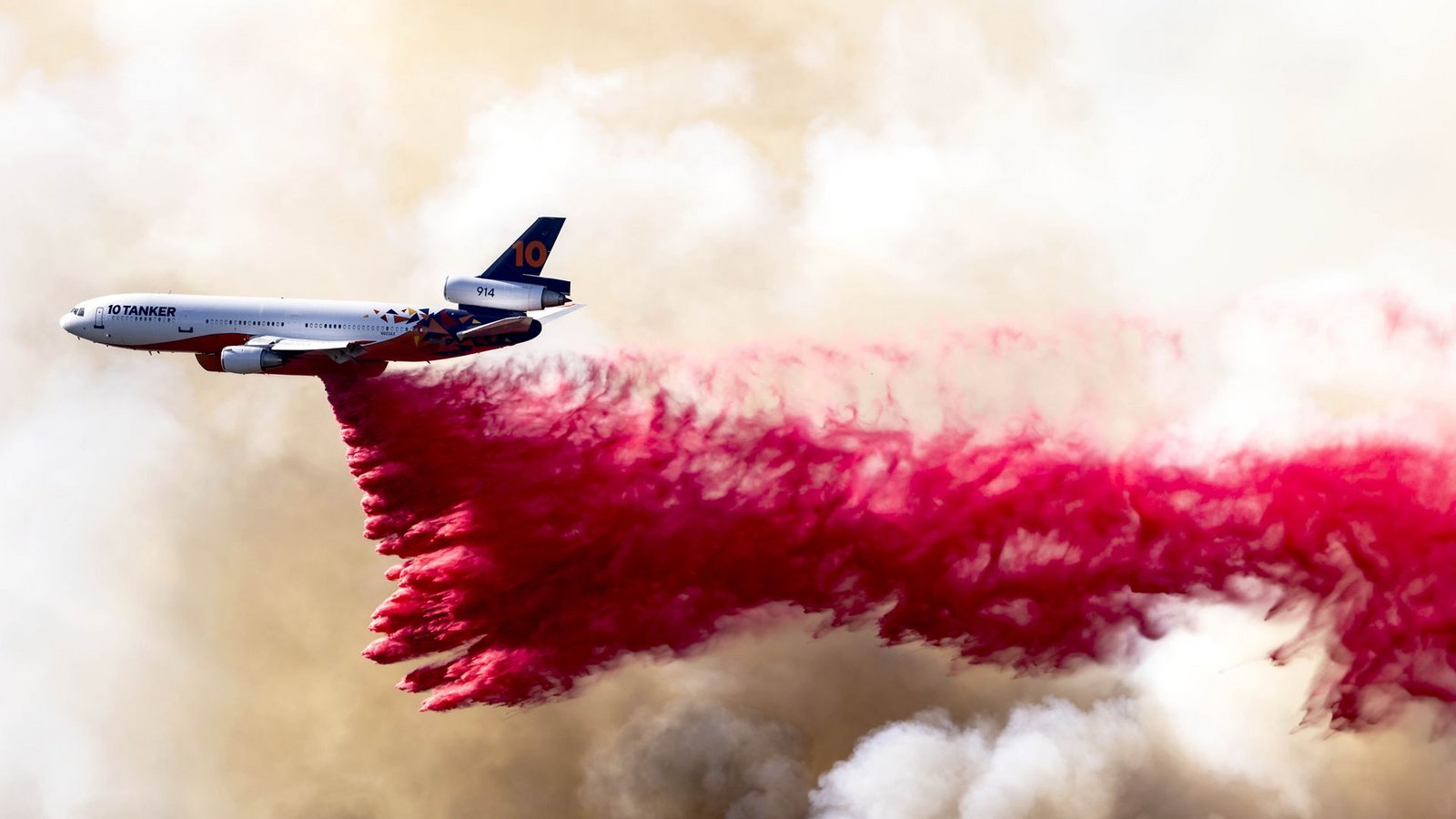 Ein Flugzeug wirft am 11. Januar 2025 eine rote Feuerlöschflüssigkeit aus Phos-Chek-Löschmittel in den Mandeville Canyon bei Los Angeles ab.Foto: Brian Cahn/Zuma Press Wire/dpa
