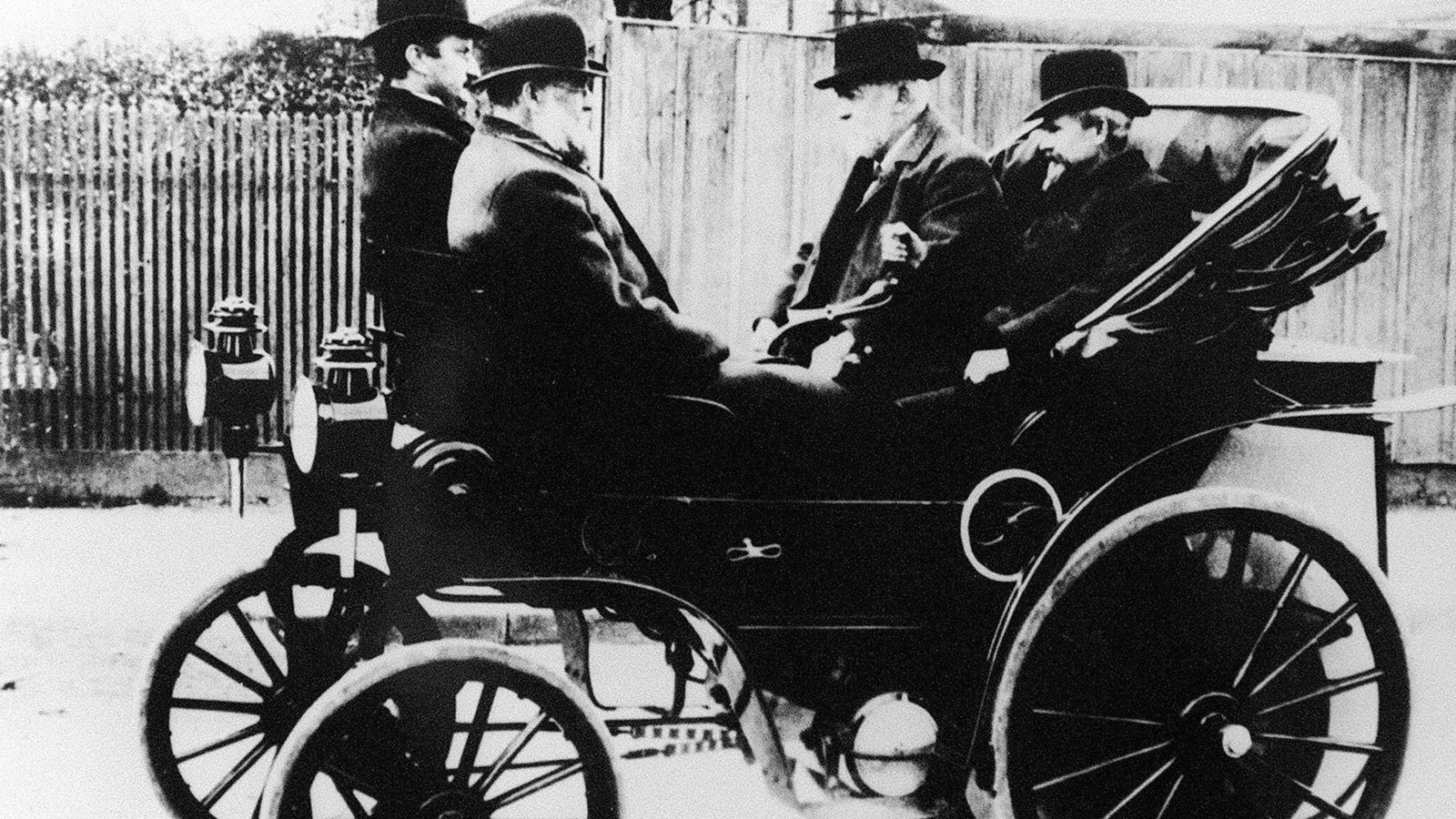 Wilhelm Maybach (re.) an der Lenkstange eines Daimler Riemenwagens gemeinsam mit Gottlieb Daimler (2. v. re.). Zusammen mit Robert Bosch gründeten sie den 1899 den Königlich Württembergischen Automobilclub.Foto: picture-alliance/dpa