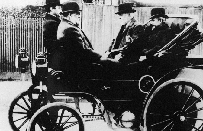 Wilhelm Maybach (re.) an der Lenkstange eines Daimler Riemenwagens gemeinsam mit Gottlieb Daimler (2. v. re.). Zusammen mit Robert Bosch gründeten sie den 1899 den Königlich Württembergischen Automobilclub.<span class='image-autor'>Foto: picture-alliance/dpa</span>