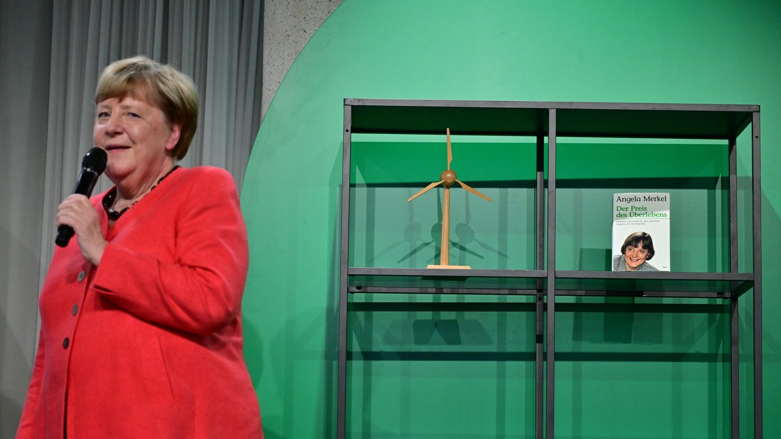 Angela Merkel (CDU), Bundeskanzlerin a.D. und ehemalige Bundesumweltministerin, spricht auf der Bühne beim Festakt "Seit 40 Jahren NaturVerbunden" zum 40. Jubiläum des Bundesumweltministeriums im Café "Moskau", während im Hintergrund ihr Buch mit dem Titel „Der Preis des Überlebens“ zu sehen ist.Foto: Sebastian Christoph Gollnow/dpa Angela Merkel (CDU), Bundeskanzlerin a.D. und ehemalige Bundesumweltministerin, spricht auf der Bühne beim Festakt "Seit 40 Jahren NaturVerbunden" zum 40. Jubiläum des Bundesumweltministeriums im Café "Moskau", während im Hintergrund ihr Buch mit dem Titel „Der Preis des Überlebens“ zu sehen ist.Foto: Sebastian Christoph Gollnow/dpa