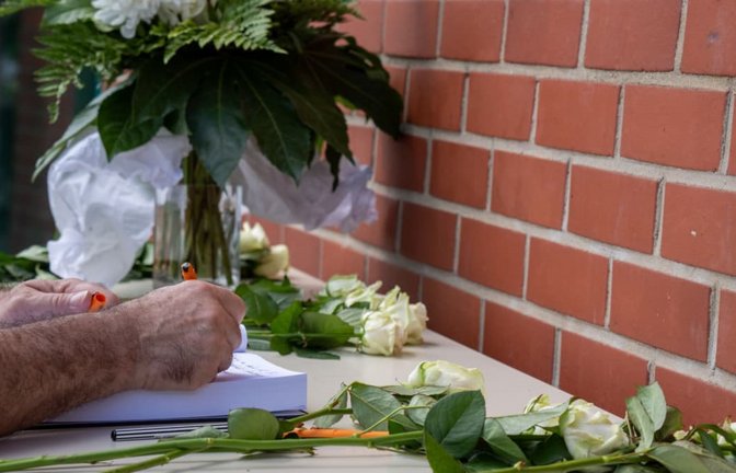 Ein Mann schreibt in das ausgelegte Kondolenzbuch auf dem Forumsplatz der Universität Trier. Nur wenige hundert Meter entfernt wurde ein 22-jähriger Student der Uni Trier von einem anderen Mann mit einem Messer getötet.<span class='image-autor'>Harald Tittel/dpa</span>