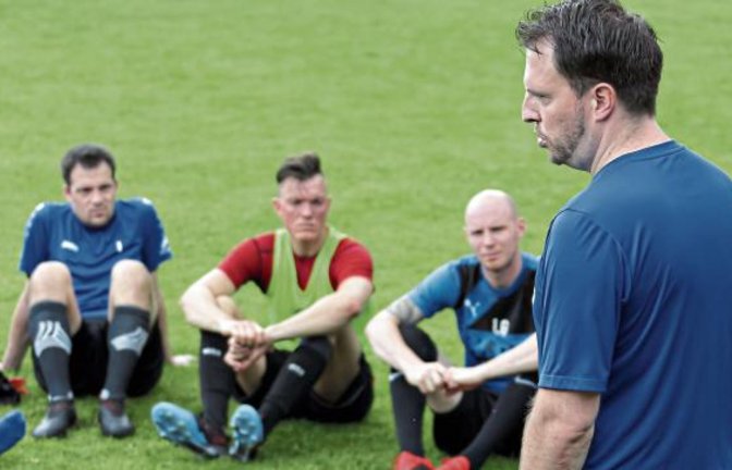 Andreas Müller spricht zu den Kickern, die das erste Training überstanden haben. Foto: Küppers
