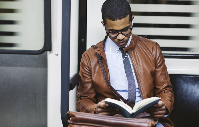 Ein Mann liest ein Buch in einer U-Bahn.<span class='image-autor'>Foto: imago/Westend61/imago stock&people</span>