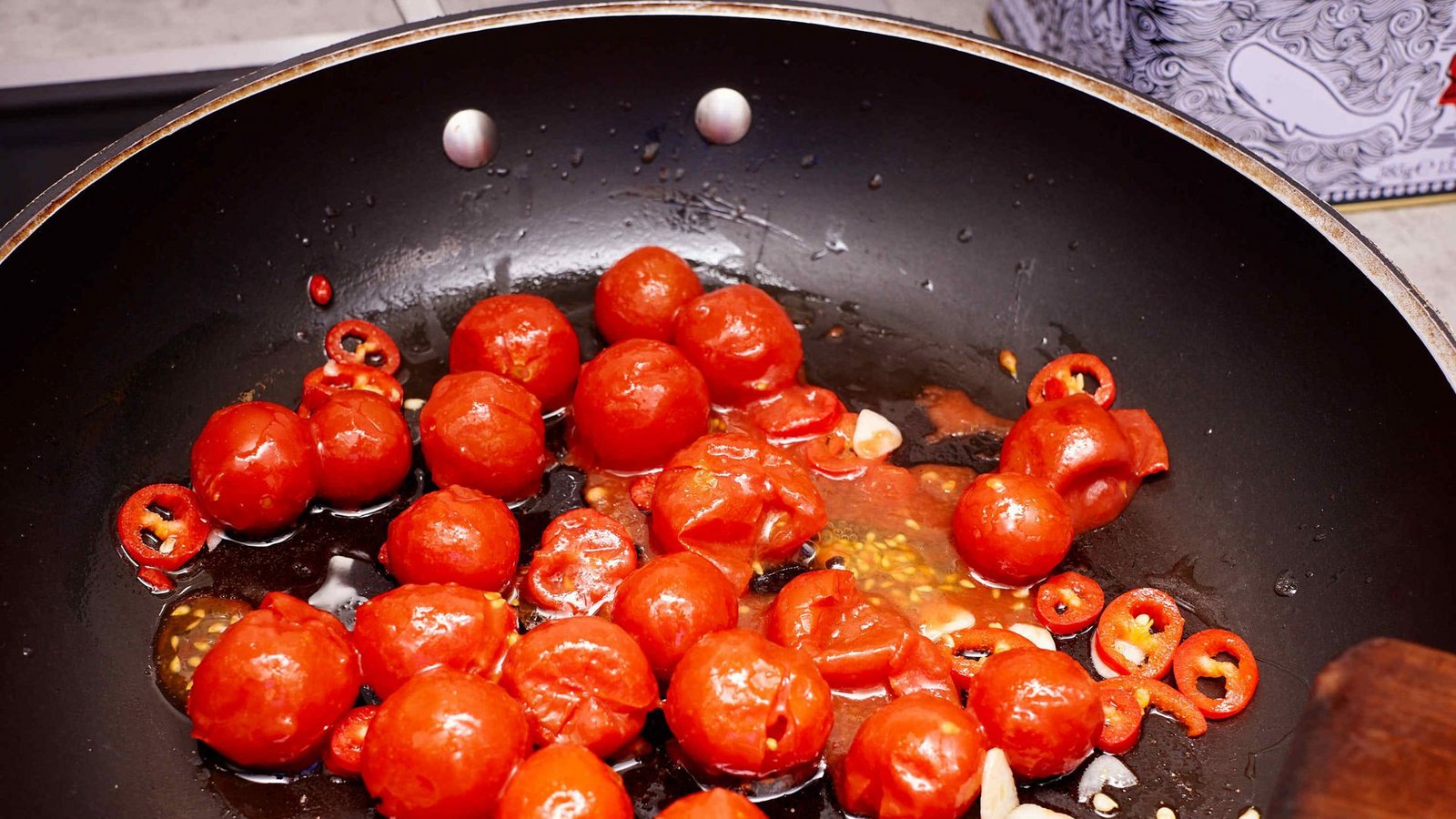 Datterini-Tomaten (ohne Saft, diesen anderweitig verwenden) dazugeben und offen bei mittlerer Hitze etwa 15 Minuten schmoren, bis sie platzenFoto: nja