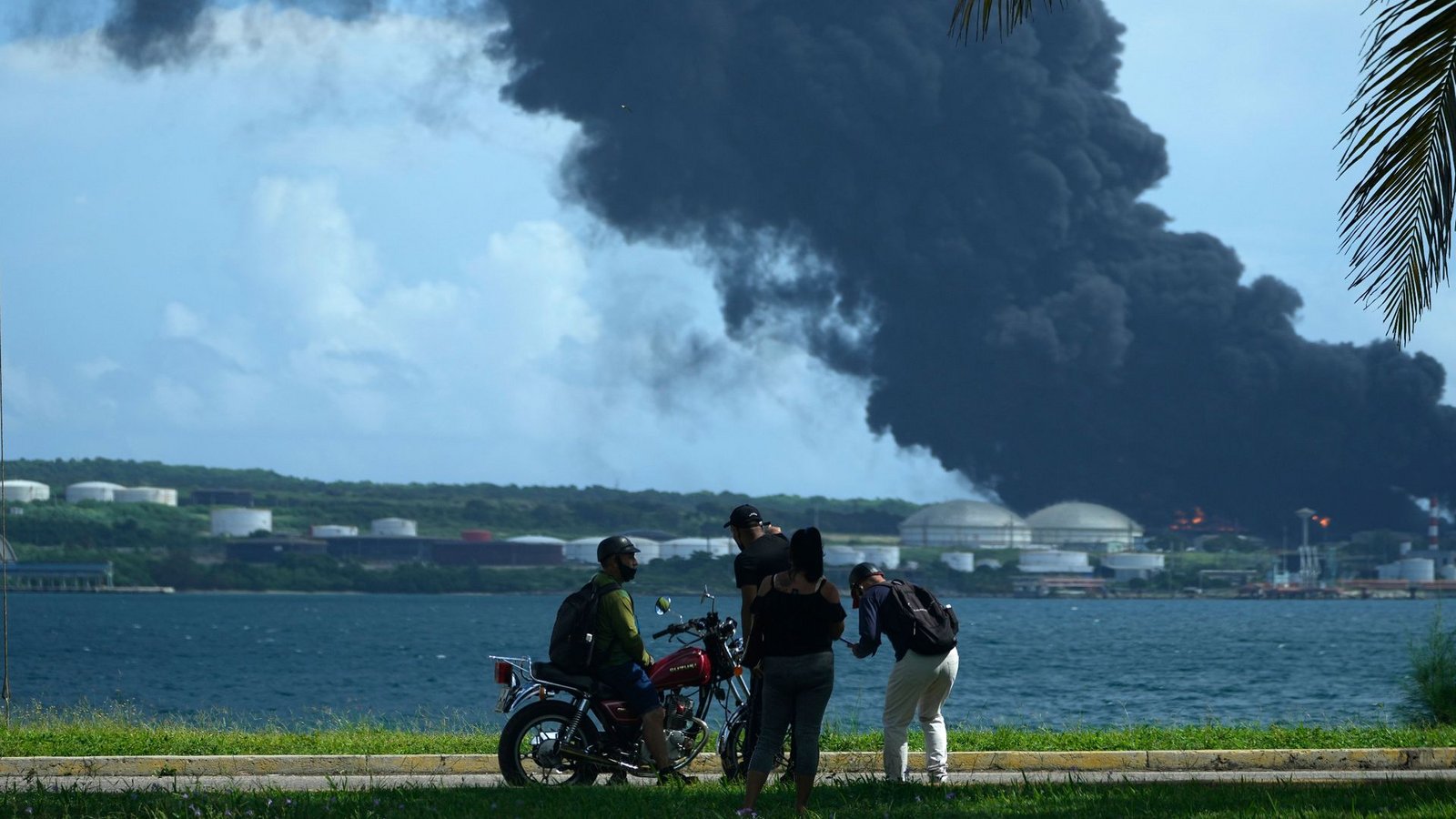 Menschen beobachten eine riesige aufsteigende Rauchwolke aus der Matanzas Supertanker-Basis.Foto: Ramon Espinosa/AP/dpa