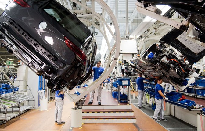 Ein neuer Volkswagen Golf 8 (l) schwebt an einer Produktionslinie im VW Werk.<span class='image-autor'>Foto: Julian Stratenschulte/dpa</span>