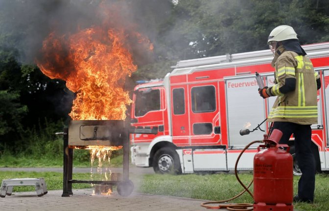 Ein Feuerwehrmann zeigt Stichflammen durch Brandbeschleuniger am Grill. Die Feuerwehr Köln demonstriert Gefahren beim Grillen, da es jährlich mehrere Tausend Grillunfälle in Deutschland zu beklagen gibt.<span class='image-autor'>Imago/Panama Pictures</span>