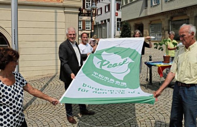 Gestern wurde sie gehisst, bis Montag hängt noch die Flagge der „Mayors für Peace“ vor dem Vaihinger Rathaus. Die Friedensgruppe Kleinglattbach hat zusammen mit dem Vaihinger Oberbürgermeister Gerd Maisch zum fünften Mal die Fahne hochgezogen. Mit dem Hissen der Flagge zeigt die Stadt Vaihingen ihr Engagement für eine atomwaffenfreie Welt. Maisch: „Mit diesem symbolischen Akt wollen wir zeigen, dass wir Menschen an der Basis ohne Atomwaffen in der Welt zusammenleben wollen.“ Foto: Bögel