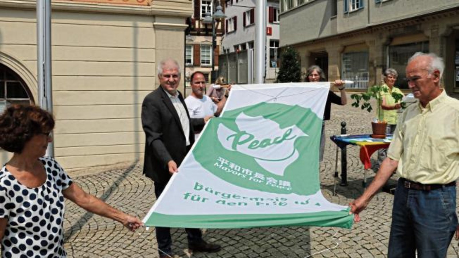 Gestern wurde sie gehisst, bis Montag hängt noch die Flagge der „Mayors für Peace“ vor dem Vaihinger Rathaus. Die Friedensgruppe Kleinglattbach hat zusammen mit dem Vaihinger Oberbürgermeister Gerd Maisch zum fünften Mal die Fahne hochgezogen. Mit dem Hissen der Flagge zeigt die Stadt Vaihingen ihr Engagement für eine atomwaffenfreie Welt. Maisch: „Mit diesem symbolischen Akt wollen wir zeigen, dass wir Menschen an der Basis ohne Atomwaffen in der Welt zusammenleben wollen.“ Foto: Bögel