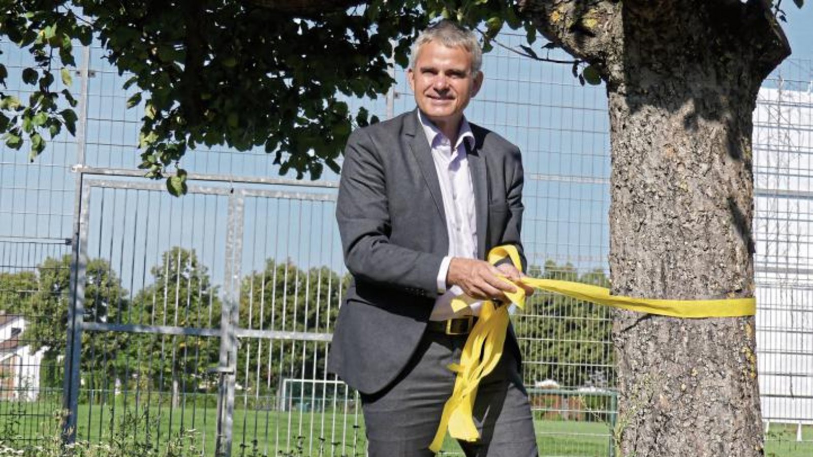 Bürgermeister Holger Albrich bringt ein gelbes Band an. Foto: p Bürgermeister Holger Albrich bringt ein gelbes Band an. Foto: p