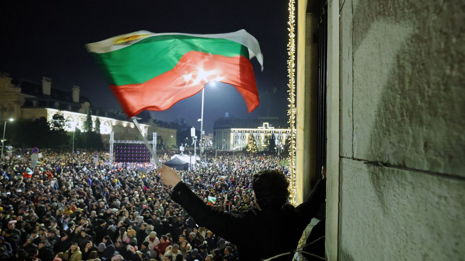 Ein Student schwenkt eine bulgarische Flagge, während eine anschwellende Menge von Zehntausenden von Bulgaren den zentralen Platz in Sofia füllt und den Rücktritt der Regierung inmitten wachsender Wut über Korruption und umstrittene Wirtschaftspolitik fordert.Foto: dpa/Valentina Petrova Ein Student schwenkt eine bulgarische Flagge, während eine anschwellende Menge von Zehntausenden von Bulgaren den zentralen Platz in Sofia füllt und den Rücktritt der Regierung inmitten wachsender Wut über Korruption und umstrittene Wirtschaftspolitik fordert.Foto: dpa/Valentina Petrova