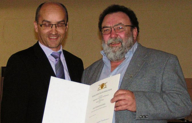 Edgar Benz (rechts) wurde von Illingens Bürgermeister Eiberger mit der Ehrennadel des Landes Baden-Württemberg ausgezeichnet. Foto: Stahlfeld