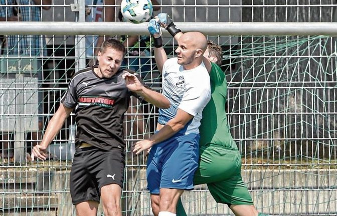 Sachsenheims Keeper Marcel Mikosch (in Grün) klärt hier zwar vor Emilio Viaes (Mitte) und Carsten Czmiel per Faust, doch der TSV Häfnerhaslach gewinnt das Stadtderby mit 2:0. Foto: Leitner