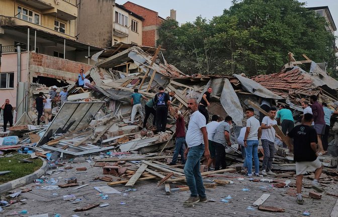 Menschen beseitigen die Trümmer eines eingestürzten Gebäudes nach einem Erdbeben in Sindirgi in der Westtürkei.<span class='image-autor'>Foto: AP/dpa/Bahadir Demirceviren</span>