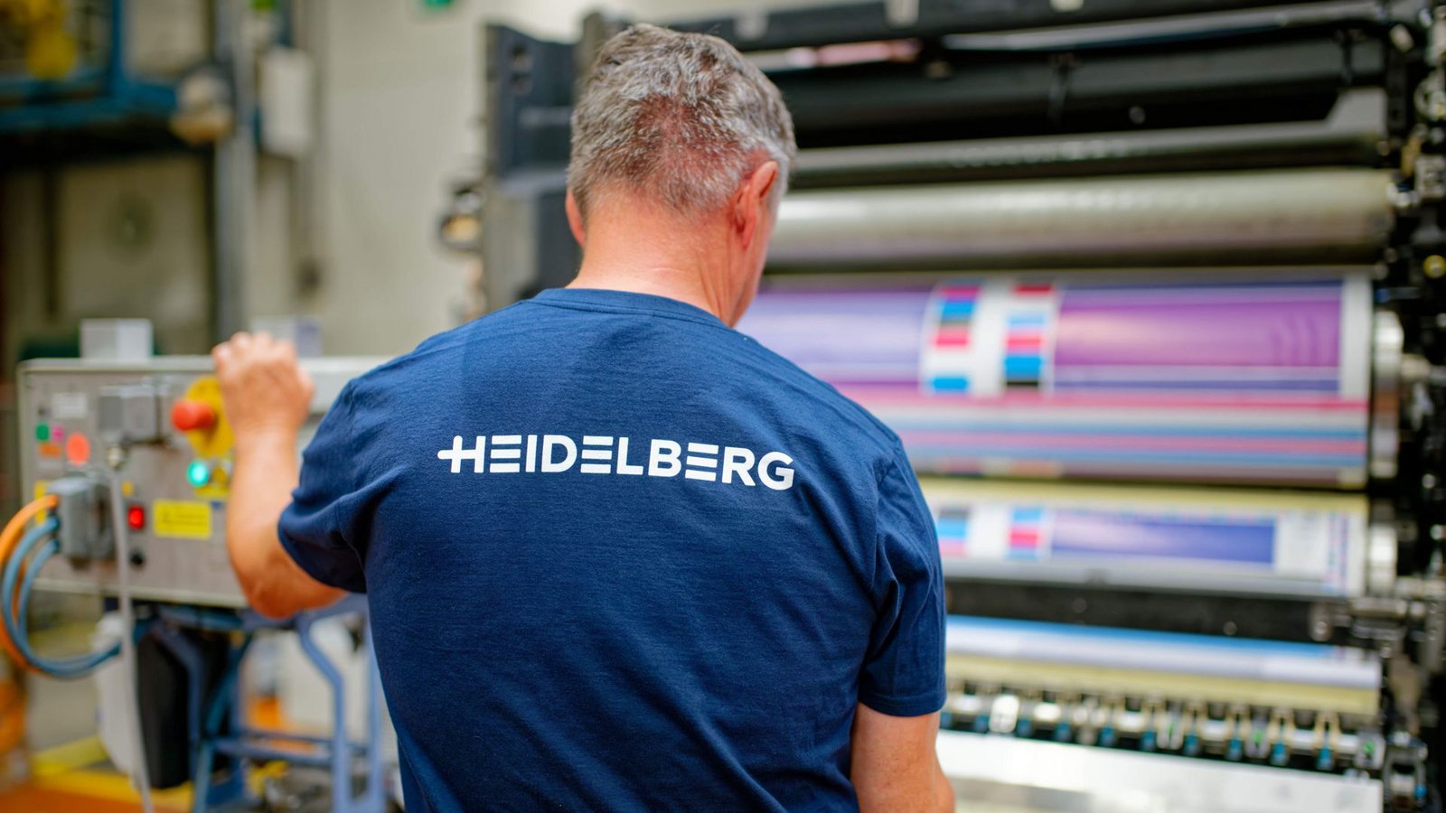Ein Mitarbeiter steht in einer Produktionshalle von Heidelberger Druckmaschinen an einem Druckwerk.Foto: Uwe Anspach/dpa