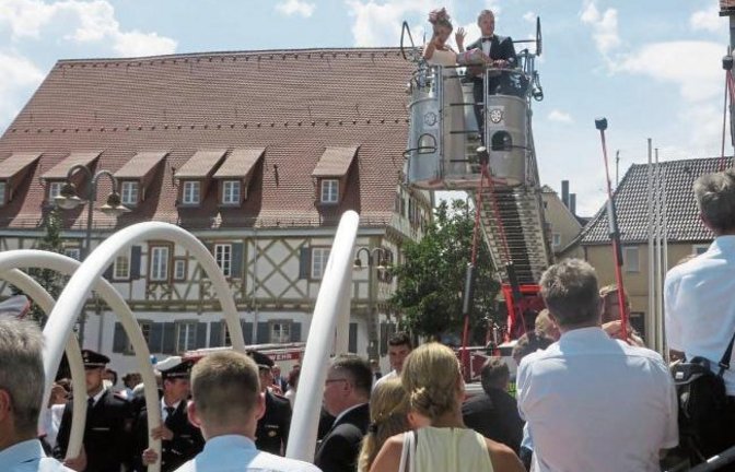 Auf dem Weg in den siebten Himmel: Josephine und ihr Mann Thomas Häberle heben am Wochenende vor dem Enzweihinger Kirchplatz ab. Die Drehleiter der Feuerwehr fungiert als Himmelsleiter. Foto: Pfisterer