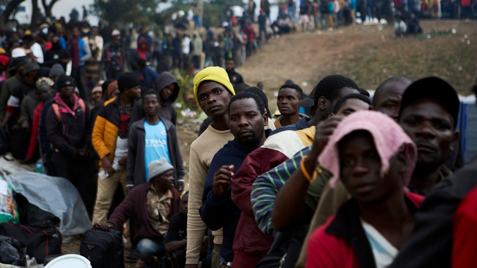 Vertriebene Migranten stehen in Durban in Südafrika vor einer Abschiebeeinrichtung Schlange.Foto: Uncredited/AP/dpa