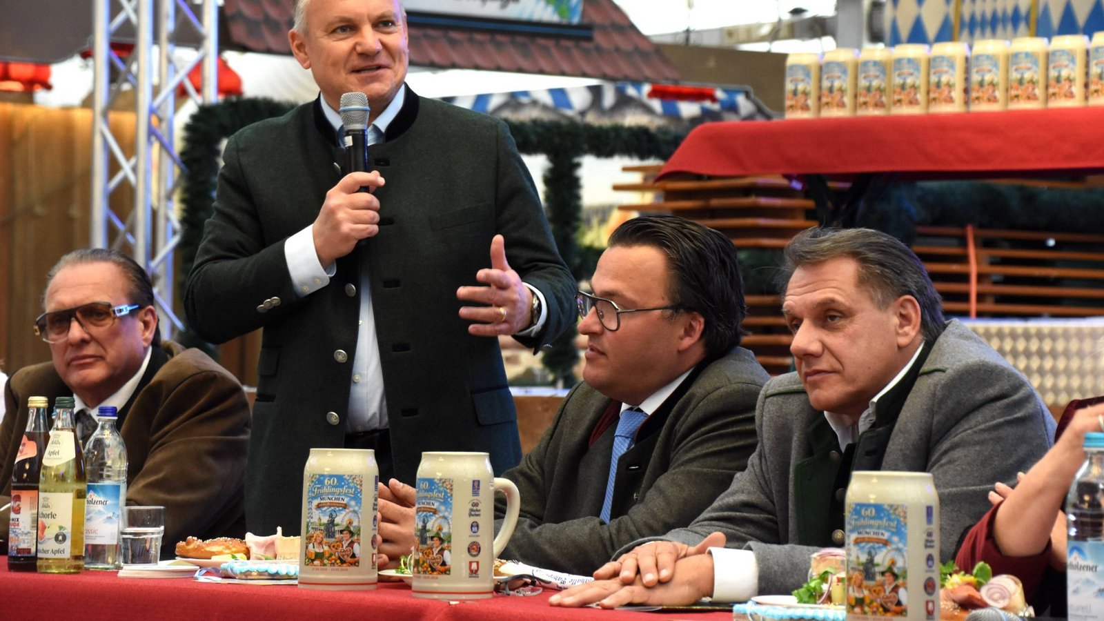 Bei der Eröffnung trinken auch der Kommunalreferent Christian Scharpf (stehend) und die anderen Ehrengäste tapfer aus den Krügen mit Schreibfehler.Foto: IMAGO/Lindenthaler Bei der Eröffnung trinken auch der Kommunalreferent Christian Scharpf (stehend) und die anderen Ehrengäste tapfer aus den Krügen mit Schreibfehler.Foto: IMAGO/Lindenthaler
