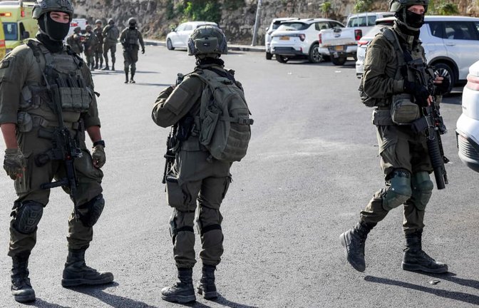 Soldaten der israelischen Armee gehen am nördlichen Kontrollpunkt von Hebron im von Israel besetzten Westjordanland entlang, nachdem es dort zu einem Schusswechsel mit bewaffneten Palästinensern gekommen war.<span class='image-autor'>AHMAD GHARABLI/afp</span>