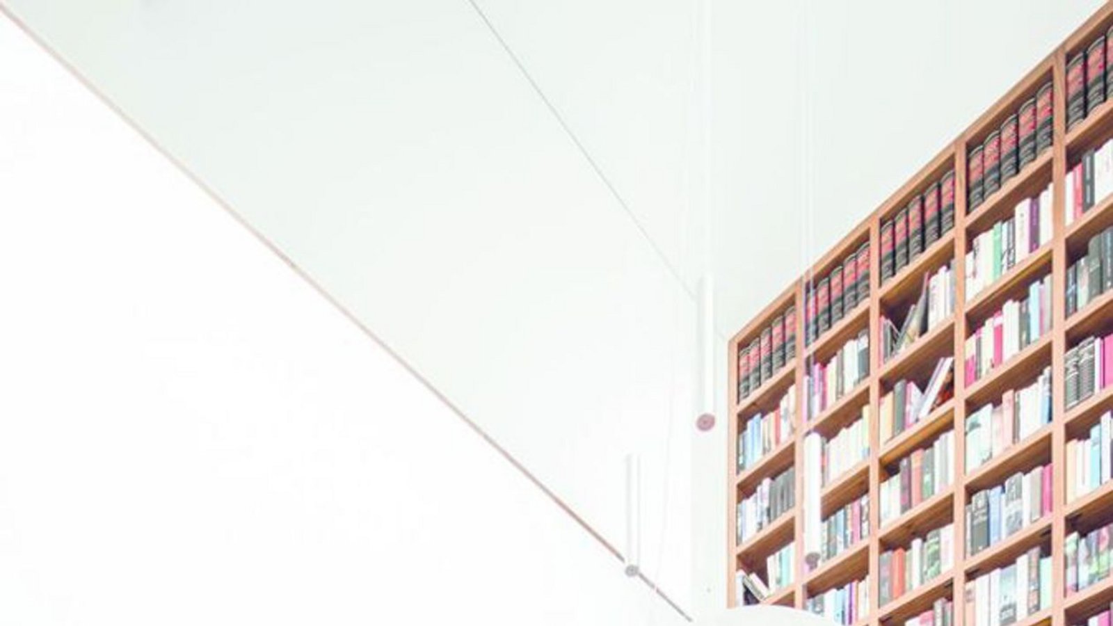 Die beeindruckende Bibliothek befindet verbindet Haupt- und Obergeschoss, ein Klavier findet auch noch Platz. Der sechs Meter hohe Luftraum befindet sich im Drehpunkt des Gebäudes, er bringt Licht und Luftigkeit ins Haus.Foto: Jose Campos Architectural Photographer