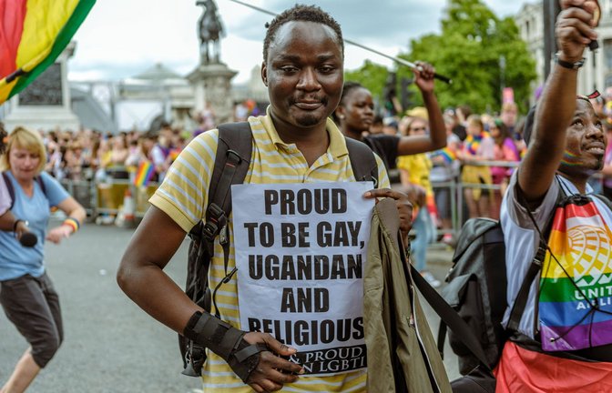 Auf einer Demonstration für die LGBTQIA+-Gemeinschaft 2022  in London trägt ein Teilnehmer ein Plakat mit der Aufschrift: „Stolz schwul, Ugander und religiös zu sein“.<span class='image-autor'>Foto: IMAGO/aal.photo</span>