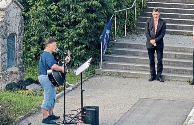 Erhard Korn (Vorsitzender der Rosa-Luxemburg-Stiftung Baden-Württemberg), Wolfram Scheffbuch (DFG-VK) und der Benninger Bürgermeister Klaus Warthon (von rechts) lauschen bei der Gedenkveranstaltung dem Gitarrenspiel von Sarah Neumann.  Foto: p