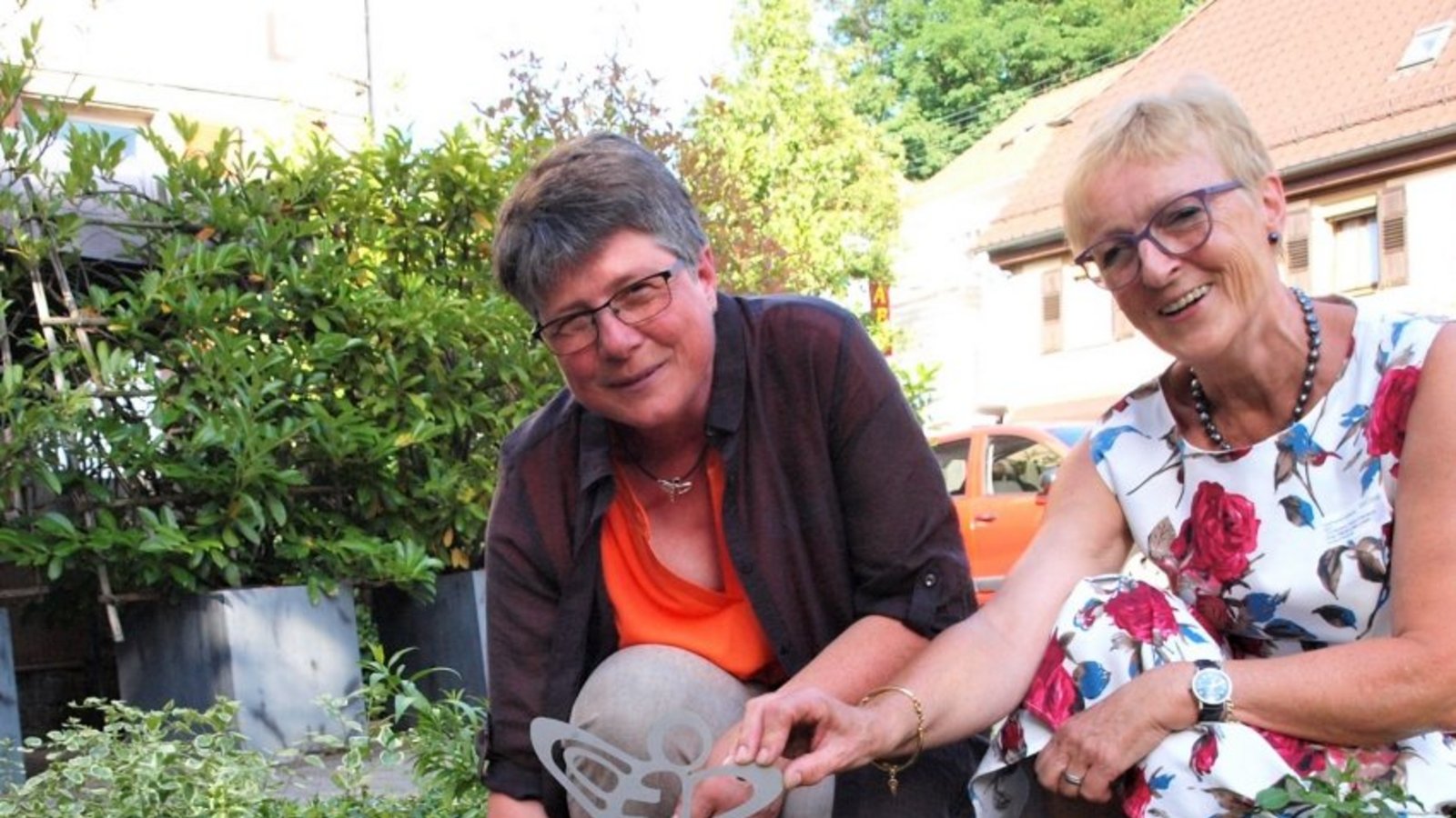 Christine Böhmerle und Marie-Luise Linckh (re.) setzen ein Namensschild und Bienensymbol in das Beet mit den zwölf Landfrauen-Rosen, die erst im vergangenen Herbst gepflanzt wurden und noch kräftig wachsen sollen. Foto: Filitz Christine Böhmerle und Marie-Luise Linckh (re.) setzen ein Namensschild und Bienensymbol in das Beet mit den zwölf Landfrauen-Rosen, die erst im vergangenen Herbst gepflanzt wurden und noch kräftig wachsen sollen. Foto: Filitz