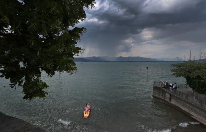 Regenwolken türmen sich über Badegäste am Bodensee. Das kann gefährlich werden. (Symbolfoto)<span class='image-autor'>Karl-Josef Hildenbrand/dpa</span>