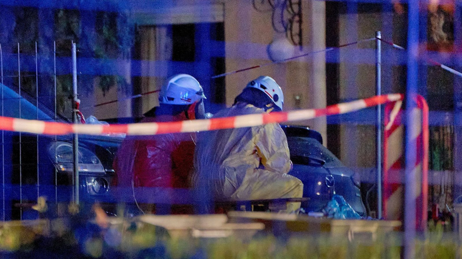 Einsatztkräfte in Schutzanzügen und mit Gasmasken sitzen im hessichen Runkel hinter einer Absperrung.Foto: Sascha Ditscher/dpa