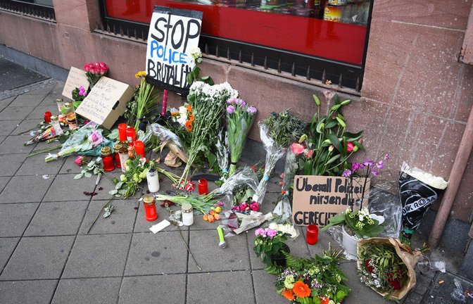Blumen, Kerzen und Schilder liegen und stehen an dem Ort, an dem am 02.05.2022 ein Mann nach einer Polizeikontrolle gestorben ist. Der Tod des Mannes nach einem Polizeieinsatz in Mannheim lässt die Wogen hoch schlagen.<span class='image-autor'>Foto: René Priebe/PR-Video /dpa</span>