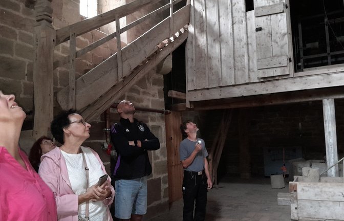 Der Zimmermeister und Schreiner Martin Büchle (rechts) erklärt den Teilnehmerinnen und Teilnehmern der Führung den baulichen Zustand der Decke in der Uhrenstube.  <span class='image-autor'>Fotos: Filitz</span>