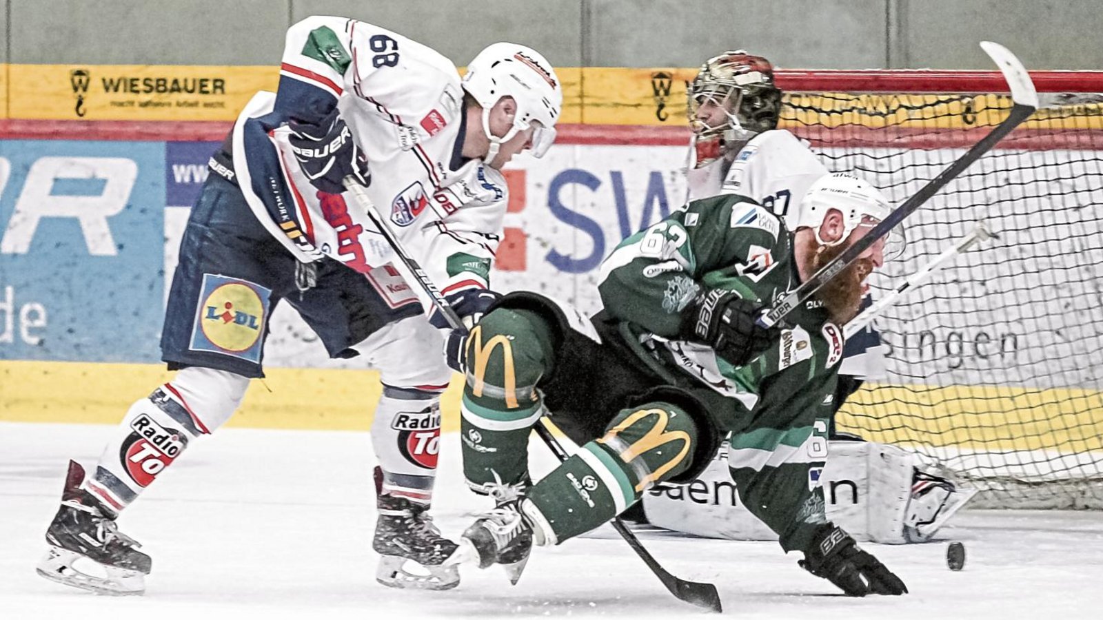 Shawn Weller wird im Derby gegen die Heilbronner Falken von Tim Bernhardt zu Fall gebracht. Zuvor hat er noch den 2:2-Ausgleich erzielt, der Puck rollt schon wieder aus dem Tor. Foto: Simecek Shawn Weller wird im Derby gegen die Heilbronner Falken von Tim Bernhardt zu Fall gebracht. Zuvor hat er noch den 2:2-Ausgleich erzielt, der Puck rollt schon wieder aus dem Tor. Foto: Simecek