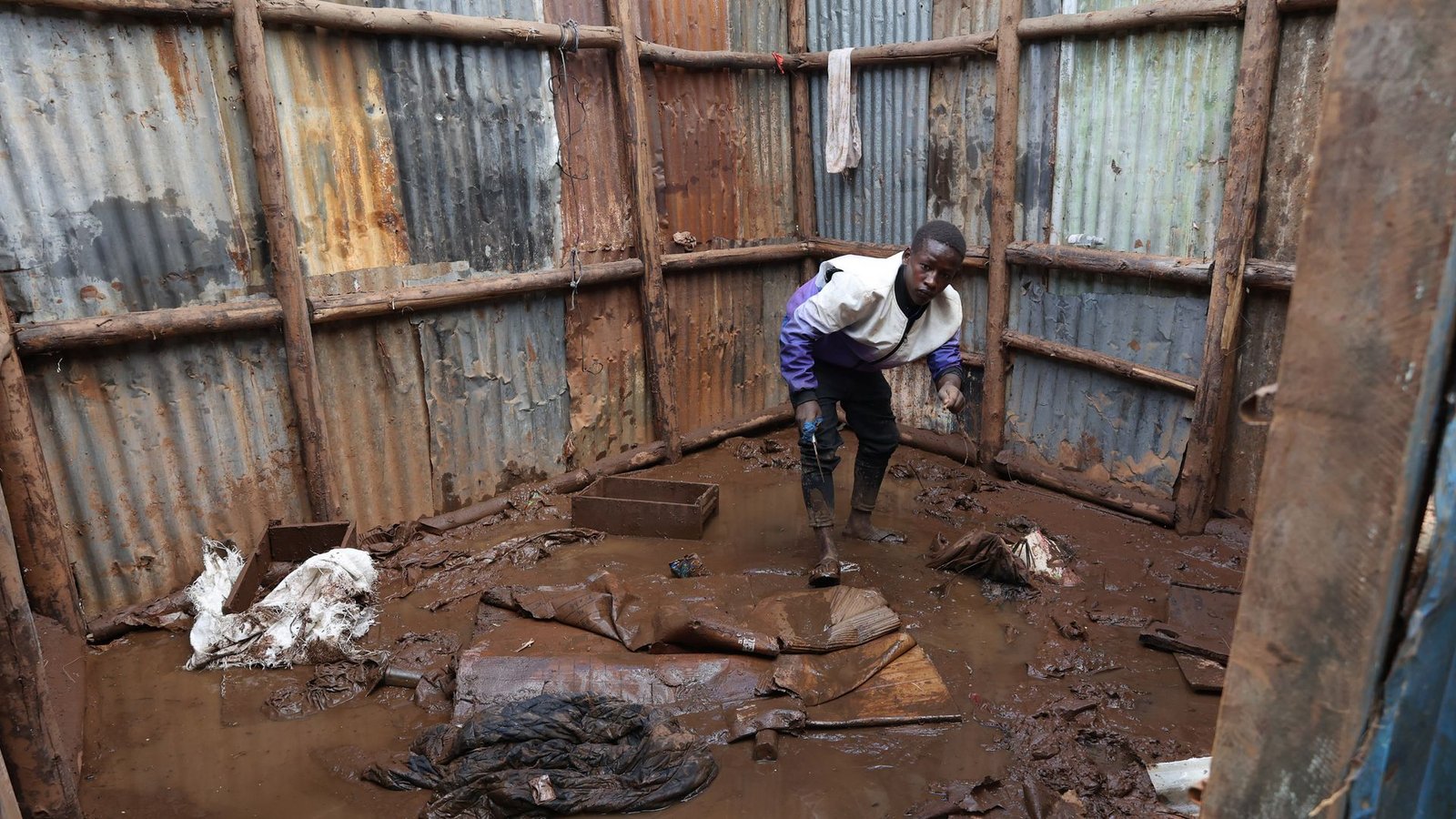 Kenia: Ein Bewohner des Mathare-Slums sammelt Gegenstände aus dem Schlamm ein, bevor er in eine Notunterkunft evakuiert wird.Foto: John Okoyo/XinHua/dpa