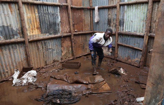 Kenia: Ein Bewohner des Mathare-Slums sammelt Gegenstände aus dem Schlamm ein, bevor er in eine Notunterkunft evakuiert wird.<span class='image-autor'>Foto: John Okoyo/XinHua/dpa</span>