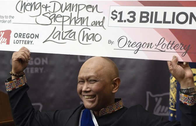 Lottogewinner Cheng Saephan hält  einen mit 1,3 Milliarden Dollar dotierten Scheck in die Höhe.<span class='image-autor'>Foto: dpa/Jenny Kane</span>