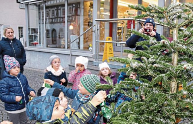 Vor dem Dorfladen in Enzweihingen wurde gestern Morgen der Weihnachtsbaum vom katholischen Kindergarten geschmückt. Der Dorfladen beteiligt sich an der Aktion der Werbegemeinschaft Vaihingen, einen Weihnachtsbaum vor dem Geschäft aufzustellen und ihn von Kindern dekorieren zu lassen. Foto: Bögel