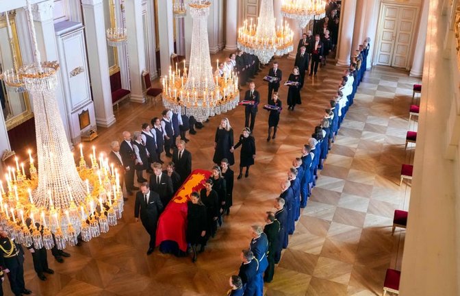 Der Sarg von König Harald V. wird am 31. August 2026 von Mitgliedern der königlichen Familie vom Roten Salon in die Palastkapelle in Oslo überführt. Hinter dem Sarg gehen Königin Mette-Marit von Norwegen und Königin Sonja von Norwegen Hand in Hand.<span class='image-autor'>Javad Parsa / NTB / AFP</span>
