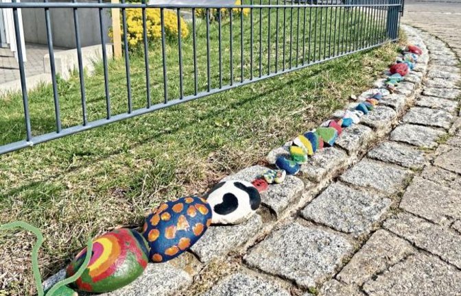 Viele Kinder machen mit und so wächst diese Raupe aus bunten Steinen, die Sebastian Staffe fotografiert hat, Stück für Stück immer weiter.
