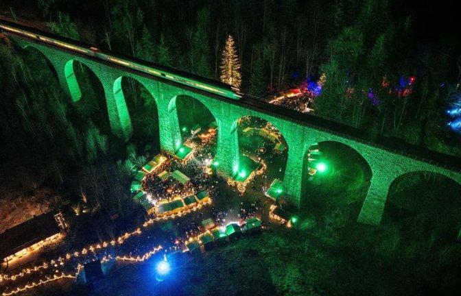 Das beleuchtete Eisenbahn-Viadukt der Höllentalbahn verläuft über dem Weihnachtsmarkt in der Ravennaschlucht. Viele Besucher kommen extra für den Weihnachtsmarkt in den Schwarzwald.<span class='image-autor'>Philipp von Ditfurth/dpa</span>
