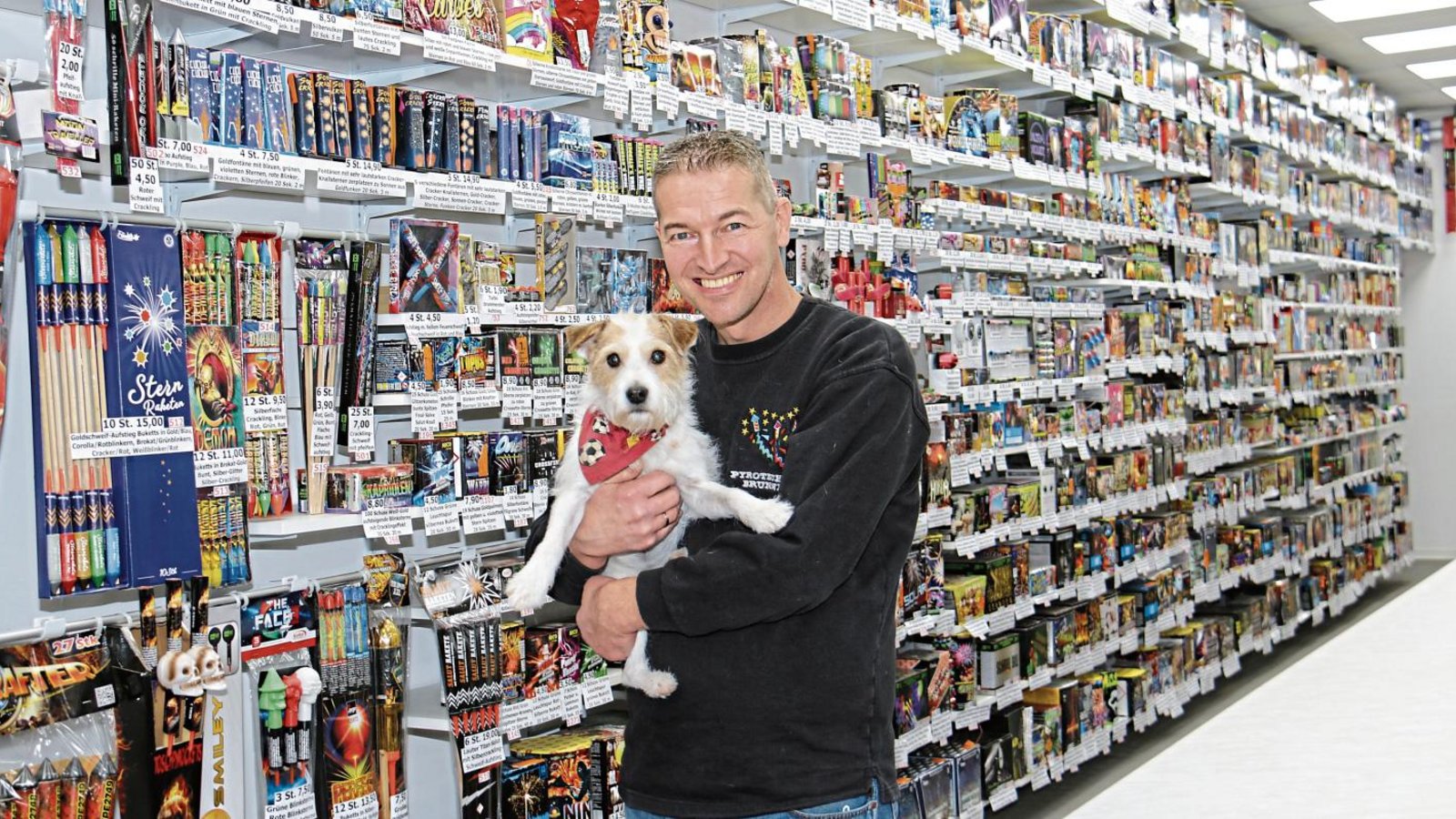 Pyrotechniker Matthias Brunner mit Hündin Kiki vor der großen Verkaufswand im Hohenhaslacher Laden.  Fotos: Rücker