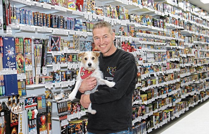 Pyrotechniker Matthias Brunner mit Hündin Kiki vor der großen Verkaufswand im Hohenhaslacher Laden.  Fotos: Rücker