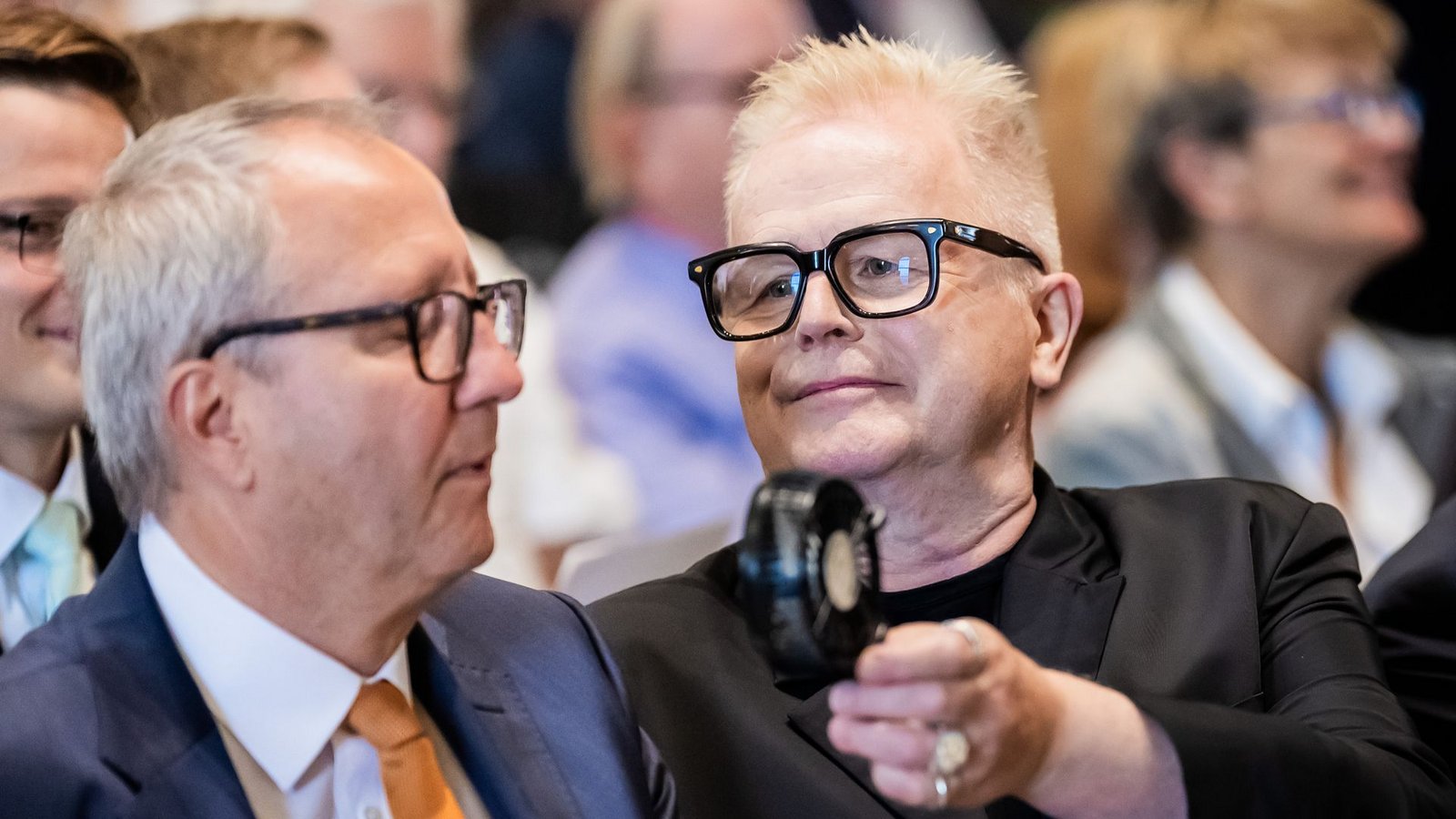 Es war warm bei der Verleihung: Herbert Grönemeyer hielt Andreas Voßkuhle, ehemaliger Präsident des Bundesverfassungsgerichts und Senatspräsident der Deutschen Nationalstiftung, daher einen Handventilator hin.Foto: Christoph Soeder/dpa Es war warm bei der Verleihung: Herbert Grönemeyer hielt Andreas Voßkuhle, ehemaliger Präsident des Bundesverfassungsgerichts und Senatspräsident der Deutschen Nationalstiftung, daher einen Handventilator hin.Foto: Christoph Soeder/dpa
