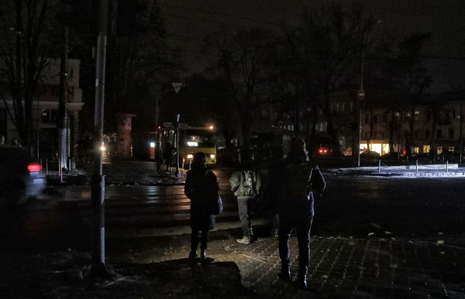 Fußgänger halten sich in Odessa an einer Kreuzung auf einer dunklen Straße auf, da die Stadt von Stromausfällen betroffen ist.<span class='image-autor'>Foto: -/Ukrinform/dpa</span>
