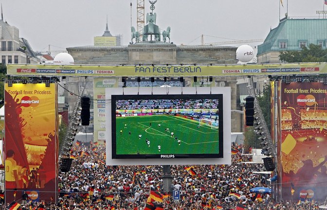 Tausende Zuschauer verfolgen 2006 auf der Fanmeile am Brandenburger Tor in Berlin das WM-Fußballspiel zwischen Deutschland und Argentinien.<span class='image-autor'>Foto: Marcel Mettelsiefen/dpa</span>