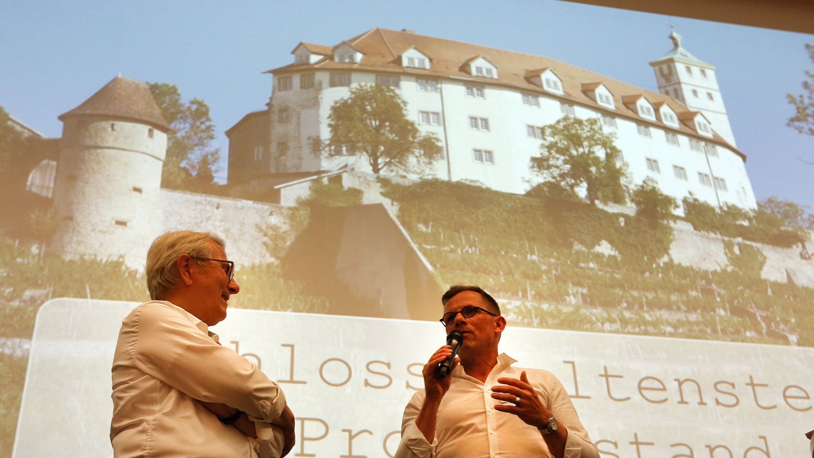 Wolfgang Scheidtweiler (links) verspricht die Fertigstellung des Schlosshotels bis Frühjahr 2027, Oberbürgermeister Uwe Skrzypek verspricht ihm im Gegenzug Wein, falls er den Zeitplan hält.